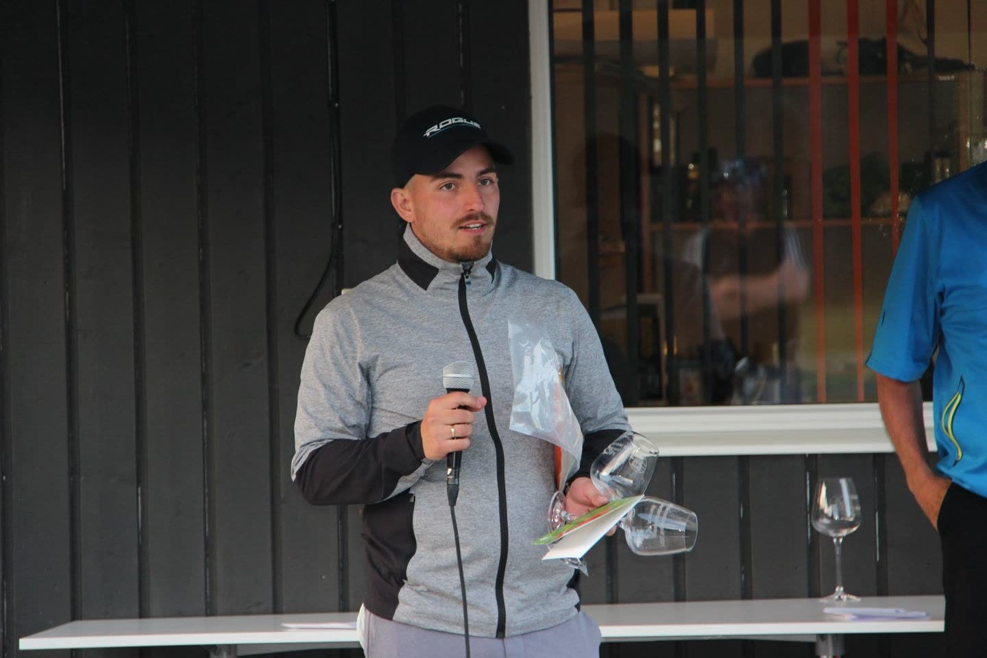 Vinneren av VM i midnattssolgolf 2021 med premien på terrassen ved klubbhuset